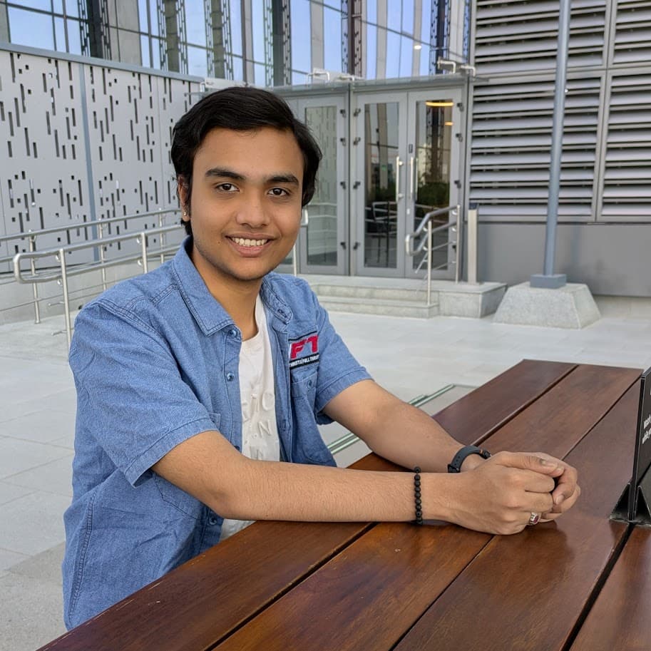 Srikar Veluvali seated outside a campus building
